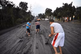 Người dân dọn tro bụi phun trào từ núi lửa Taal ở thị trấn Tanauan, tỉnh Batangas, Philippines. (Ảnh: AFP/TTXVN)