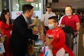 Tặng hoa, quà chúc mừng các vị khách đầu tiên đến xông đất Đà Nẵng bằng đường hàng không. (Ảnh: Trần Lê Lâm/TTXVN)