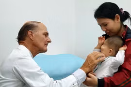 Bác sỹ McKay McKinnon khám lâm sàng cho một trẻ em bị dị dạng hốc mắt. (Ảnh: TTXVN phát)