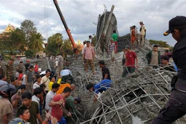 Lực lượng cứu hộ tìm kiếm nạn nhân dưới đống đổ nát sau vụ sập công trình xây dựng ở chùa Prasat Korkchak thuộc tỉnh Siem Reap, Campuchia. (Ảnh: THX/TTXVN)