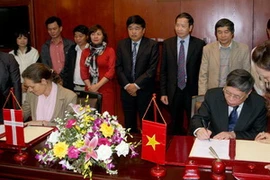 Thứ trưởng Bộ Nông nghiệp và Phát triển Nông thôn Bùi Bá Bổng và bà Rosenholm, Phó Đại sứ Đan Mạnh tại Việt Nam ký thỏa thuận. (Ảnh: Đình Huệ/TTXVN)