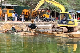 Nạo vét bùn đất hồ Trúc Bạch. (Ảnh: Bùi Tường/TTXVN)