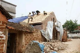 Sửa chữa nhà tại làng cổ Đường Lâm. (Ảnh: Nhật Anh/TTXVN)