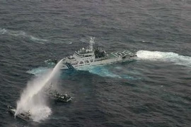 Tàu của lực lượng phòng vệ bờ biển Nhật Bản (phải) phun vòi rồng chặn tàu của Đài Loan (trên, trái) ở gần quần đảo tranh chấp ngày 24/1. AFP/ TTXVN