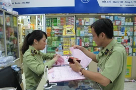 Lực lượng quản lý thị trường Hà Nội đang kiểm tra các cơ sở kinh doanh tân dược tại Trung tâm thuốc Hapu (Ảnh: Đức Duy/Vietnam+)