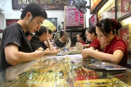 Khách hàng đang giao dịch vàng miếng (Ảnh: TTXVN)