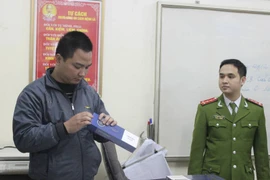 Lực lượng chức năng kiểm tra số thuốc lá điếu nhập lậu vừa thu giữ (Ảnh: Đức Duy/Vietnam+)