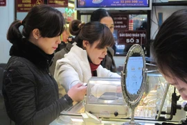 Khách hàng đang giao dịch vàng miếng (Ảnh: Vietnam+)