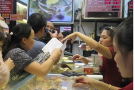 Khách hàng đang giao dịch vàng miếng (Ảnh: Vietnam+)