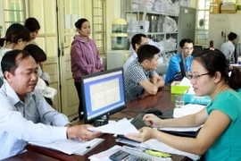 Tiếp nhận và giải quyết hồ sơ cho người tham gia Bảo hiểm y tế, Bảo hiểm xã hội. (Ảnh: Dương Ngọc/TTXVN)