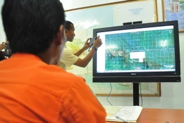 Nhân viên Cơ quan tìm kiếm và cứu nạn quốc gia Indonesia theo dõi địa hình khu vực ở Jayapura trên bản đồ nhằm tìm kiếm máy bay mất tích. (Nguồn: AFP/TTXVN)