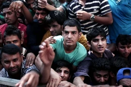 Người nhập cư trái phép chờ đợi được đăng ký bên ngoài một đồn cảnh sát ở đảo Kos, Hy Lạp. (Nguồn: AFP/TTXVN)