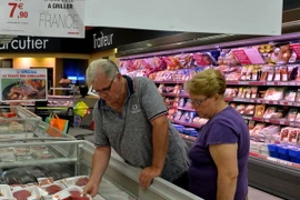 Khách hàng chọn mua các sản phẩm thịt tại siêu thị "Super U" ở Neuville-aux-Bois (Pháp). (Nguồn: AFP/TTXVN)