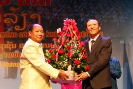 Bộ trưởng An ninh Lào Somkeo Silavong (trái) tặng hoa chúc mừng Cơ quan Đại diện Bộ Công an Việt Nam tại Lào. (Ảnh: Phạm Kiên/TTXVN)