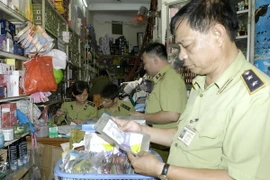 Lực lượng chức năng kiểm tra sản phẩm chăm sóc da mặt tại một cửa hàng. (Ảnh: Trần Việt/TTXVN)