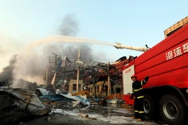 Lính cứu hỏa nỗ lực dập lửa sau vụ nổ ở Thiên Tân. (Nguồn: THX/TTXVN)