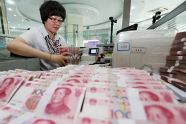 Kiểm tiền nhân dân tệ tại ngân hàng ở Lianyungang, tỉnh Giang Tô, miền Đông Trung Quốc. (Nguồn: THX/TTXVN)