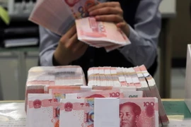 Kiểm đồng nhân dân tệ tại ngân hàng Mega ở Đài Bắc, Đài Loan. (Nguồn: AFP/TTXVN)