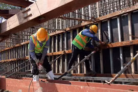 Công nhân thi công trên công trường Dự án hầm chui nút giao thông Nguyễn Văn Linh-Nguyễn Hữu Thọ (Quận 7, Thành phố Hồ Chí Minh). (Ảnh: Tiến Lực/TTXVN)