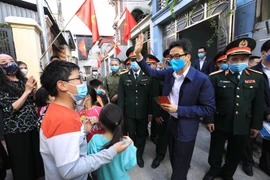 Phó Thủ tướng Vũ Đức Đam với người dân tại tổ dân phố số 10 và 11, nhà máy Z153 - Cục Kỹ thuật, Bộ Quốc phòng (huyện Đông Anh, Hà Nội). (Ảnh: Thành Đạt/TTXVN)