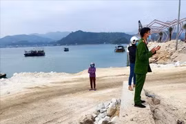 Lực lượng chức năng tại hiện trường khu vực nơi doanh nghiệp đổ trộm đất đá xuống vịnh Bái Tử Long. (Ảnh: TTXVN phát)