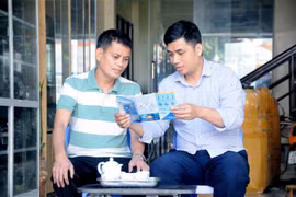 Cán bộ bảo hiểm xã hội tuyên truyền chính sách Bảo hiểm xã hội tự nguyện cho người dân. (Ảnh: Quang Quyết/TTXVN)