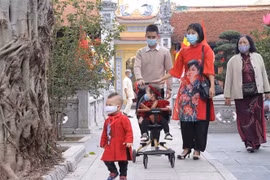 Người dân đi lễ Phật, vãn cảnh chùa trong ngày đầu Xuân. (Ảnh: Hoàng Hiếu/TTXVN)