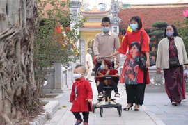 Người dân đi lễ Phật, vãn cảnh chùa trong ngày đầu Xuân. (Ảnh: Hoàng Hiếu/TTXVN)