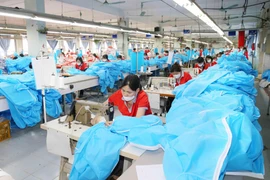 Công ty cổ phần May Chiến Thắng chuyển đổi dây chuyền sang may quần áo bảo hộ y tế. (Ảnh: Phương Hoa/TTXVN)