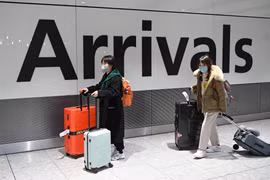 Hành khách đeo khẩu trang để phòng tránh lây nhiễm virus corona chủng mới gây dịch viêm phổi tại sân bay Heathrow, London, Anh, ngày 28/1/2020. (Ảnh: AFP/TTXVN)