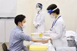 Nhân viên y tế lấy mẫu xét nghiệm kháng thể cho người dân nhằm đánh giá mức độ lây lan của dịch COVID-19, tại Tokyo. (Ảnh: Kyodo/TTXVN)