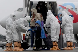 Nhân viên xịt khử khuẩn cho hành khách tại sân bay Kazan, Nga nhằm ngăn dịch COVID-19 lây lan, ngày 21/4/2020. (Ảnh: THX/TTXVN)