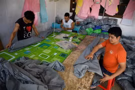 Công nhân may đồ bảo hộ y tế cá nhân và khẩu trang phòng lây nhiễm COVID-19 tại Jakarta, Indonesia. (Ảnh: AFP/TTXVN)