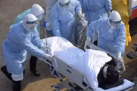 Nhân viên y tế chuyển bệnh nhân nhiễm virus corona chủng mới tới khu vực cách ly. (Ảnh: THX/TTXVN)