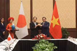 Trưởng ban Tổ chức Trung ương Phạm Minh Chính tặng quà lưu niệm cho ông Nikai Toshihiro. (Ảnh: Quốc Dũng/TTXVN)