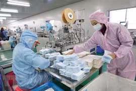 Công nhân may khẩu trang y tế tại một nhà máy ở Trung Quốc. (Ảnh: THX/TTXVN)