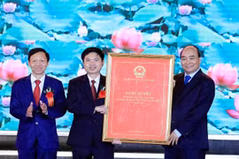 Thủ tướng Nguyễn Xuân Phúc trao Nghị quyết của Ủy ban Thường vụ Quốc hội về thành lập thị xã Duy Tiên, Hà Nam. (Ảnh: Thống Nhất/TTXVN)
