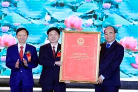 Thủ tướng Nguyễn Xuân Phúc trao Nghị quyết của Ủy ban Thường vụ Quốc hội về thành lập thị xã Duy Tiên, Hà Nam. (Ảnh: Thống Nhất/TTXVN)