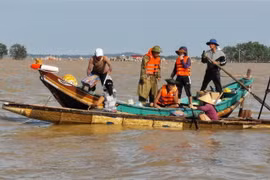 Người dân Lệ Thủy, Quảng Bình chèo thuyền đi lấy hàng cứu trợ do địa hình phức tạp khiến lực lượng chức năng không thể tiếp cận. (Ảnh: Thành Đạt/TTXVN)