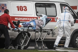 Nhân viên y tế chuyển bệnh nhân nhiễm COVID-19 tới bệnh viện ở Moskva, Nga. (Ảnh: AFP/TTXVN)