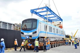 Toa xe đầu tiên của đoàn tàu tuyến metro số 1 được tháo dỡ, đưa xuống xe vận chuyển. (Ảnh: Tiến Lực/TTXVN)