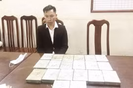 Đối tượng Vàng A Lồng, sinh năm 1989, trú tại bản Buổi Hương, xã Mường Nhà, huyện Điện Biên, tỉnh Điện Biên cầm đầu cùng vật chứng là 20 bánh heroin tại cơ quan điều tra. (Ảnh: Doãn Tấn/TTXVN)