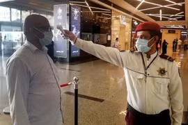 Kiểm tra thân nhiệt cho người dân tại một trung tâm mua sắm ở Riyadh, Saudi Arabia nhằm ngăn chặn sự lây lan của dịch COVID-19. (Ảnh: AFP/TTXVN)