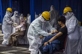 Nhân viên y tế lấy mẫu xét nghiệm COVID-19 cho người dân tại tỉnh Tây Java, Indonesia. (Ảnh: THX/TTXVN)