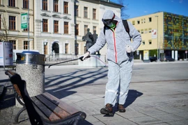 Nhân viên Slovenia phun thuốc khử trùng nhằm ngăn dịch COVID-19 lây lan tại Kranj. (Ảnh: AFP/TTXVN)