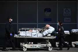 Nhân viên y tế chuyển bệnh nhân nghi mắc COVID-19 vào một bệnh viện ở New York, Mỹ ngày 14/5/2020. (Ảnh: AFP/TTXVN)
