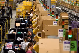 Nhân viên đóng gói hàng hóa cho khách hàng tại trung tâm dịch vụ của Amazon. (Ảnh: AFP/TTXVN)