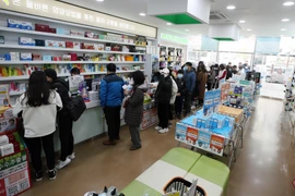 Người dân xếp hàng chờ mua khẩu trang tại một hiệu thuốc ở Gwangju, cách thủ đô Seoul của Hàn Quốc 329km về phía nam, ngày 15/3/2020. (Ảnh: Yonhap/TTXVN)