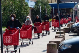 Người dân xếp hàng bên ngoài siêu thị ở Bologna, Italy ngày 21/3/2020, trong bối cảnh dịch COVID-19 lan rộng. (Ảnh: THX/TTXVN)