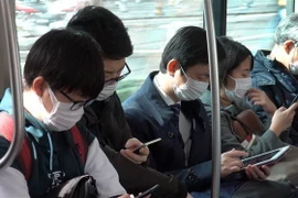 Người dân đeo khẩu trang phòng tránh lây nhiễm dịch COVID-19 tại Tokyo, Nhật Bản. (Ảnh: THX/TTXVN)